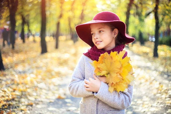 Dívka v klasickém kabátě a klobouku v podzimním parku. Podzimní sezóna, móda, dětství. — Stock fotografie