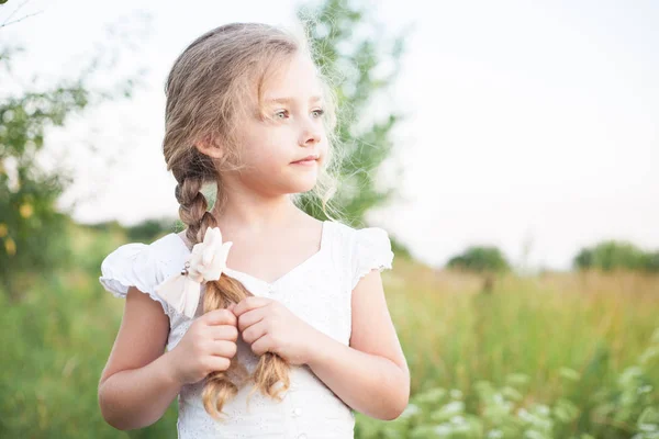 Close-up portret van een mooi klein meisje buitenshuis in de zomer. — Stockfoto