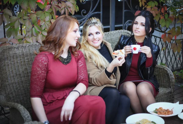 Trois femmes boivent du café et mangent des pâtes dans un café . — Photo