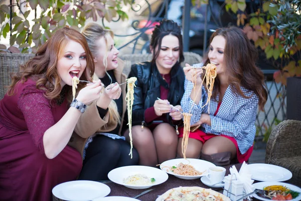Vier junge Frauen beim Mittagessen in einem Café. — Stockfoto