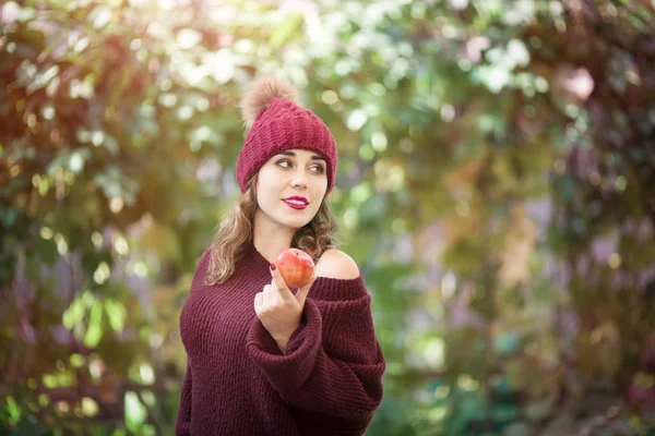 Šťastný životní styl portrét krásné mladé ženy v teplém podzimním klobouku s jablkem v ruce. — Stock fotografie