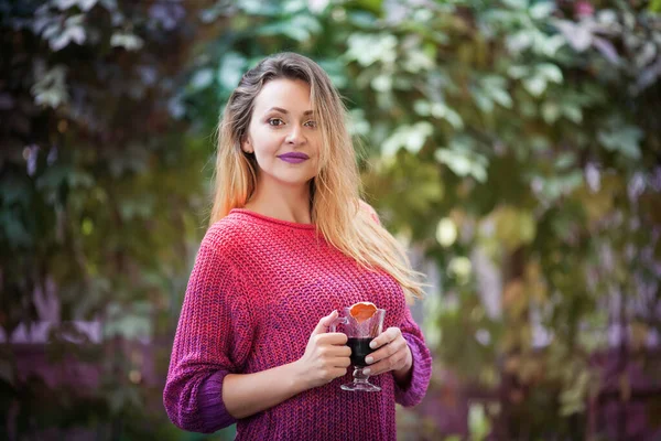 Jovem mulher bonita bebe vinho quente no outono ao ar livre . — Fotografia de Stock