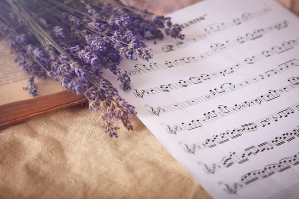 Lawenda i notatki do muzyki papierowej na starym tle tkaniny w stylu vintage. — Zdjęcie stockowe