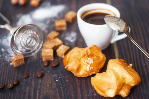 Šálek horké černé kávy s domácími profiterly na rustikálním stole — Stock fotografie