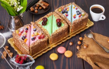 Masanın üstünde renkli pastalar var. Kahvaltıda kahve ve tatlı.