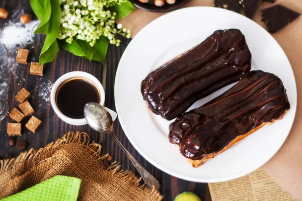 Eclairs fatti in casa in glassa di cioccolato. Cottura di eclairs nella cucina di casa . — Foto Stock