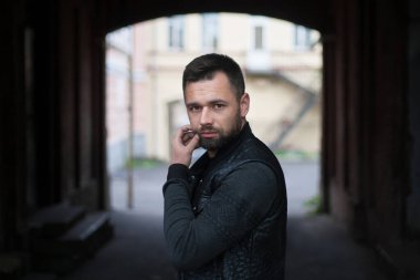 Düşünceli sakallı genç adam öğleden sonra şehir dışında..