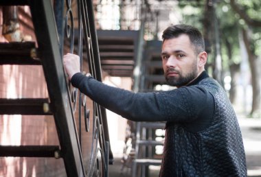 Düşünceli sakallı genç adam öğleden sonra şehir dışında..