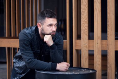 Düşünceli sakallı genç adam öğleden sonra şehir dışında..