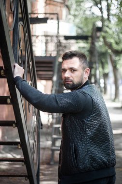 Düşünceli sakallı genç adam öğleden sonra şehir dışında..