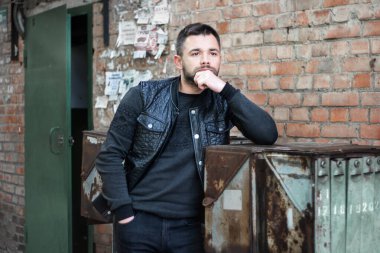 Düşünceli sakallı genç adam öğleden sonra şehir dışında..