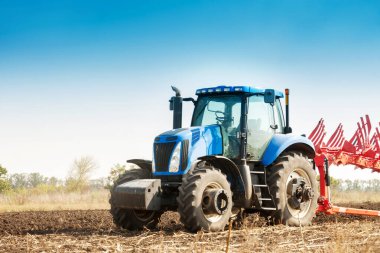 Traktör tarlayı sürüyor, tohum ekmek için toprağı işliyor. Tarım kavramı.