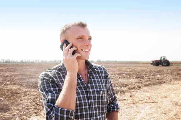 Jonge Aantrekkelijke Man Met Telefoon Bij Een Tractor Tractor Bestuurder — Stockfoto