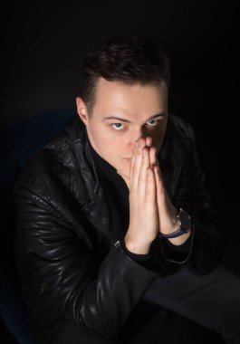 Stüdyoda siyah arka planda çekici bir adamın portresi. Genç, ciddi adam..