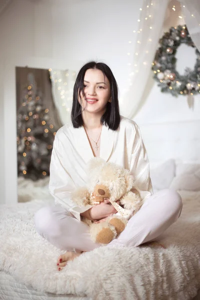 Joven hermosa mujer en pijama en el dormitorio. Vacaciones de invierno. —  Fotos de Stock