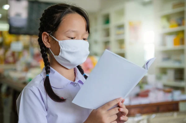 Covid-19 ve Bangkok Tayland 'daki Dust PM2.5 salgını nedeniyle okul kapalı olduğu için ilkokul öğrencisi evde ödev yapıyor.