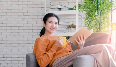 Coronavid virüsü salgınından dolayı evde çalışan güzel genç öğrenciler, Covid-19, dünya çapında yeni normal bir hayata sebep oldu. Sosyal uzaklık için bir kitap okudu ve kahve içti.