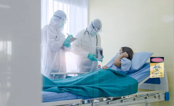 Hasta Coronavirus COVID-19 enfeksiyonu üzerinde çalışan doktor ve hemşire asistanları özel bir odada, özel bir odada, karantina odasında muayene ediliyor. Doktorlar ve hastalar temizlik odasında. 