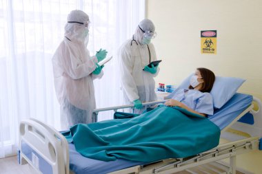 Hasta Coronavirus COVID-19 enfeksiyonu üzerinde çalışan doktor ve hemşire asistanları özel bir odada, özel bir odada, karantina odasında muayene ediliyor. Doktorlar ve hastalar temizlik odasında. 