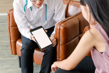 Akıl hastaları konsepti. Genç doktorun psikoloğu tabletle çalışıyor. Ofiste kadın akıl hastalarının raporlarına bakın.