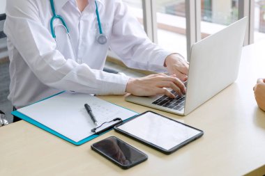 Akıllı Doktor, hastanenin iş yerinde bilgisayar, cep telefonu ve tabletle çalışıyor.  