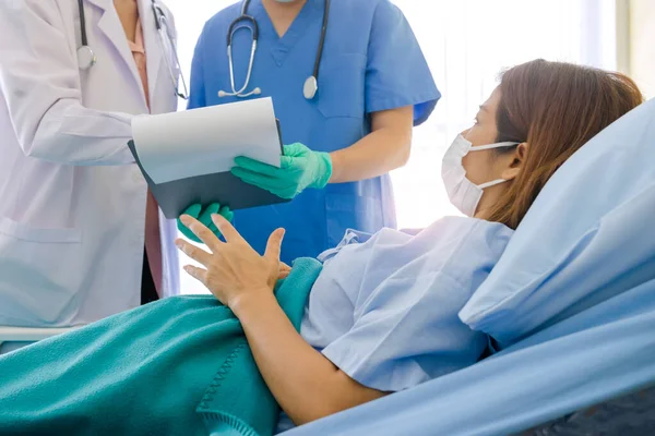 Hasta Coronavirus COVID-19 enfeksiyonu üzerinde çalışan doktor ve hemşire asistanları özel bir odada, özel bir odada, karantina odasında muayene ediliyor. Doktorlar ve hastalar temizlik odasında. 