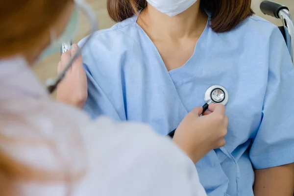 Hasta Coronavirus COVID-19 enfeksiyonuyla çalışan Stethoscope kalp kullanan doktor özel bir odada, özel bir odada, karantina odasında muayene ediliyor. Doktorlar ve hastalar temizlik odasında. 