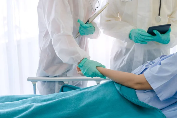 Hasta Coronavirus COVID-19 enfeksiyonu üzerinde çalışan doktor ve hemşire asistanları özel bir odada, özel bir odada, karantina odasında muayene ediliyor. Doktorlar ve hastalar temizlik odasında. 