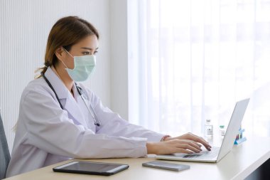 Bir kadın doktor, Coronavirus, Covid-19 enfeksiyonlu bir hasta olan kan testi hastanesinin ofisinde defterle çalışıyor..