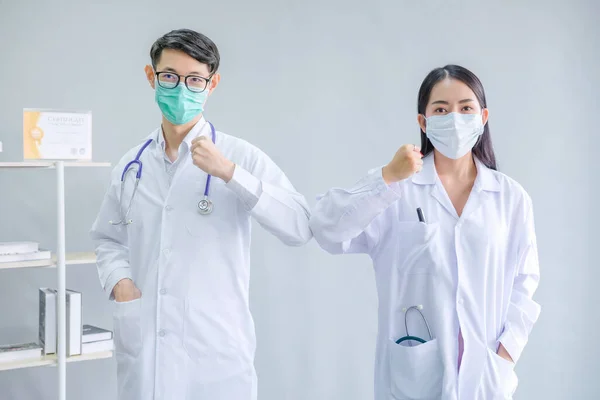 Virüs salgını sırasında doktor kahraman konsepti. Doktor dünya çapında yayılan Coronavirus salgınıyla savaşıyor. Doktor adam ve doktor kadın beyaz bir arkaplanda kavga ediyorlar. 