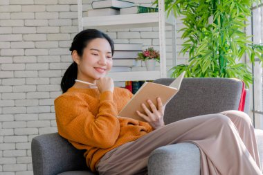 Coronavid virüsü salgınından dolayı evde çalışan güzel genç öğrenciler, Covid-19, dünya çapında yeni normal bir hayata sebep oldu. Sosyal uzaklık için bir kitap okudu ve kahve içti.