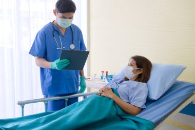 Hasta Coronavirus COVID-19 enfeksiyonu üzerinde çalışan doktor ve hemşire asistanları özel bir odada, özel bir odada, karantina odasında muayene ediliyor. Doktorlar ve hastalar temizlik odasında. 