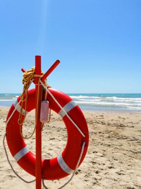 deniz, kum ve gökyüzü nün arka planına karşı lifebuoy