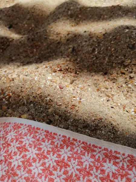 Gölgede kum ve bir bez parçası — Stok fotoğraf