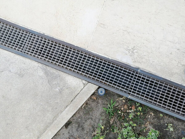 drainage systems. metal structures for water drainage - sewerage and grate on the ground close-up. house construction, storm cranes. landscaping and trellis on the ground