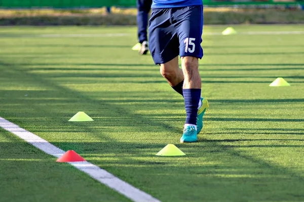 Voetbal voetballers tijdens de training team voor de wedstrijd. Oefeningen voor voetbal voetbal jeugdteam. Speler oefeningen met bal en marker kegels — Stockfoto