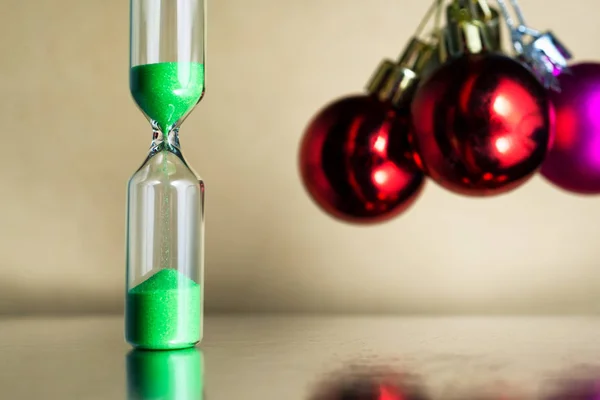 Modern güzel yeşil Noel ya da Noel ve yeni yıl topları ile kum saati.