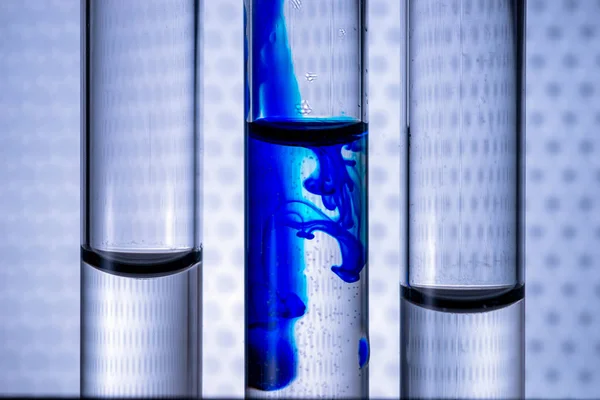 Nahaufnahme Flüssigkeit blauer Farbe Tinte in Wasser in einem Reagenzglas von vitro. Konzeptidee zu einem medizinischen Thema. — Stockfoto