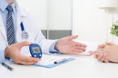 Doktor şeker ölçüm glikoz düzeyi gösterir. Doktor ve hasta diyabet konsültasyon ofis veya klinik.