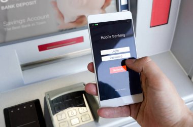 Bir kredi kartı kullanmadan bir Atm para çekmek. Bir telefon ile mobil bankacılık için bir giriş ekranı tutan kişi.