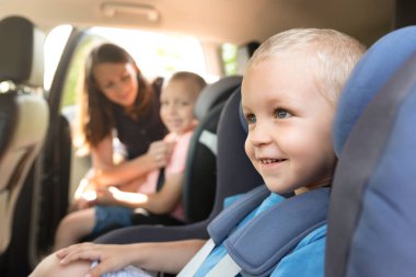 Çocuklar araba koltuğuna kemerini. Anne çocuklarını arabada hakkında icabına bakar. Güvenli seyahat kavramı