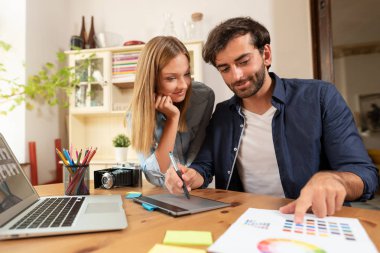 Projede çalışan grafik tasarımcıları. Çift serbest evde çalışma. 