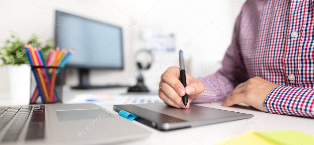 Graphic designer working on digital tablet. Freelancer workplace at home
