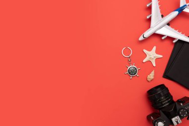 Kırmızı zemin üzerine yaz seyahat aksesuarları. Seyahat planlama üstten görünüm kavramı