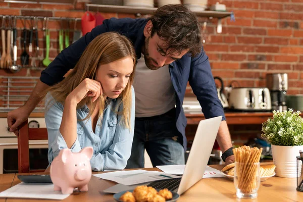 Family budget and finances. Young woman puts a coin into the piggy bank.