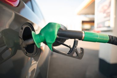 Gri bir otomobilin yakıt tankında benzin pompa meme. Bir benzin istasyonunda araç yakıt ikmali