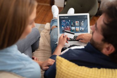 Vod hizmeti film izlerken için dizüstü bilgisayar kullanarak bir çift. Video On Demand televizyon abonelik kredi kartı ile satın