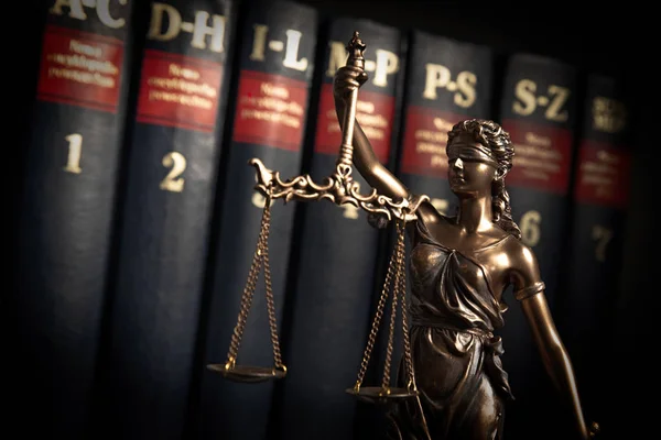 Lady justice, themis, statue of justice on books background. Law concept with justice figurine in library