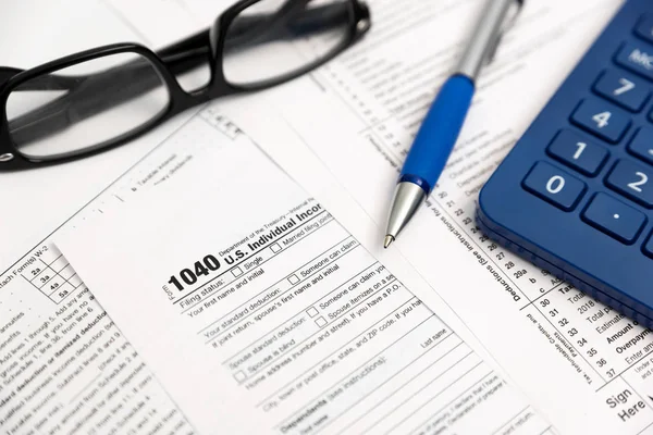 U.S. Individual income tax return. Tax form 1040 with eyeglasses and pen