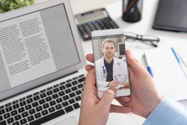 Akıllı telefon ekranında steteskoplu bir doktor. Teletıp ya da tele sağlık kavramı.